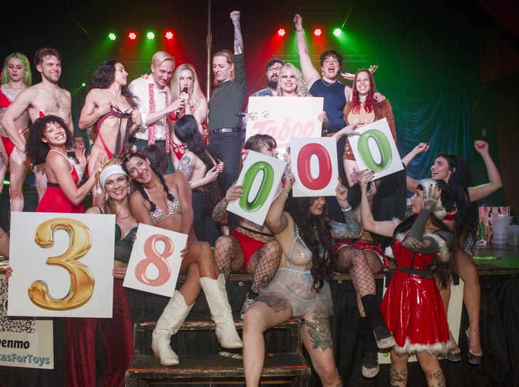A group of strippers pose with number signs on stage at a Christmas event