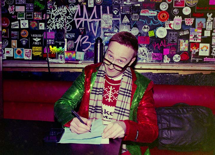 A man sits backstage at a Portland Christmas event