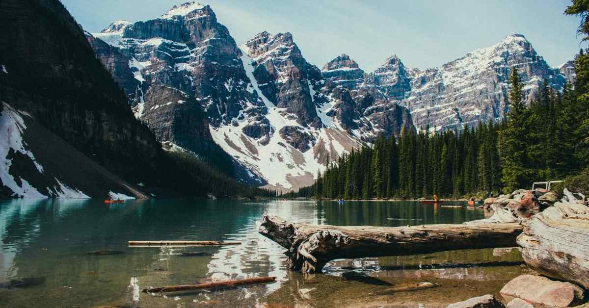 A lake covered by snowy mountains and trees