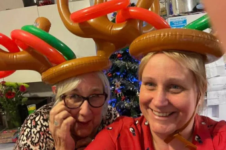 Two women take a selfie in inflatable reindeer antlers