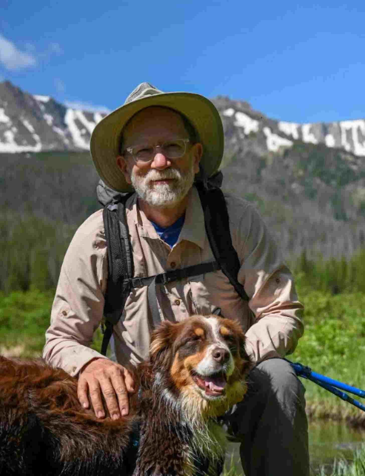 Photo of a man with a dog in the mountains