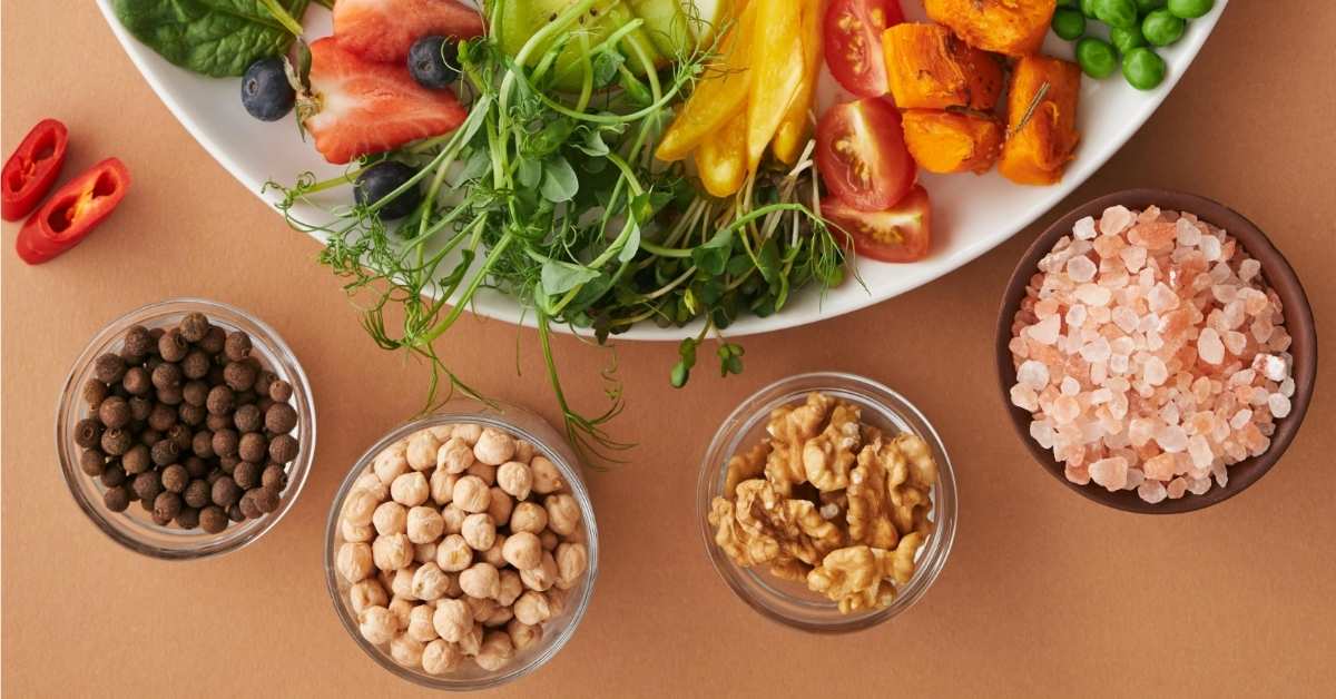 An array of vegan-friendly food on a wooden table, some in small bowls. 
