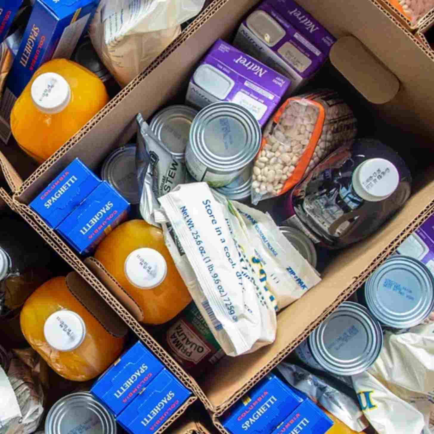A pile of food in pacakages, boxes, cans, and bottles.