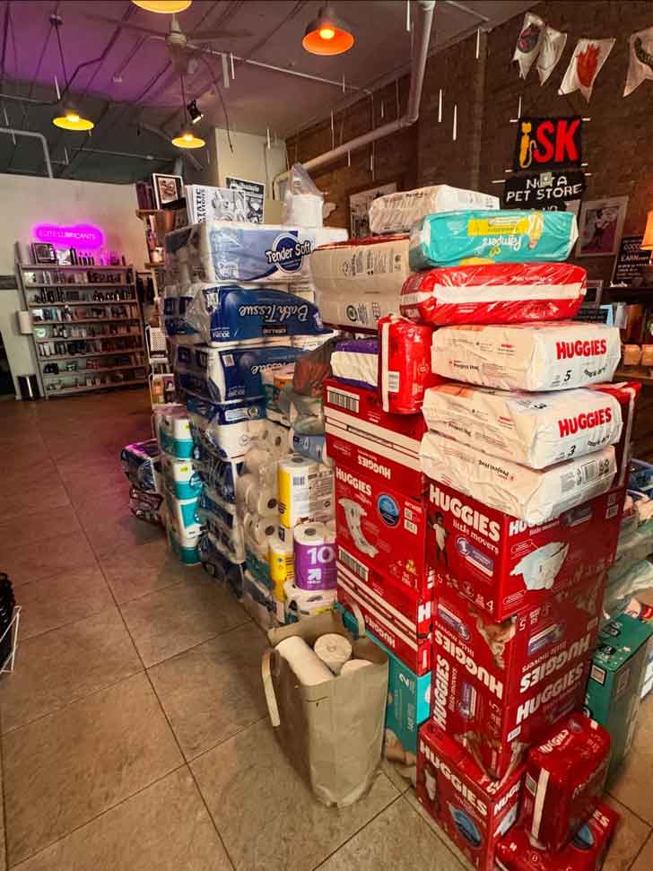A stack of diapers, toilet paper, and other essential goods piles up inside Smitten Kitten in Minneapolis