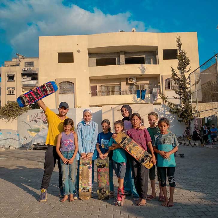 A group of young skateboarders pose with their boards in Gaza