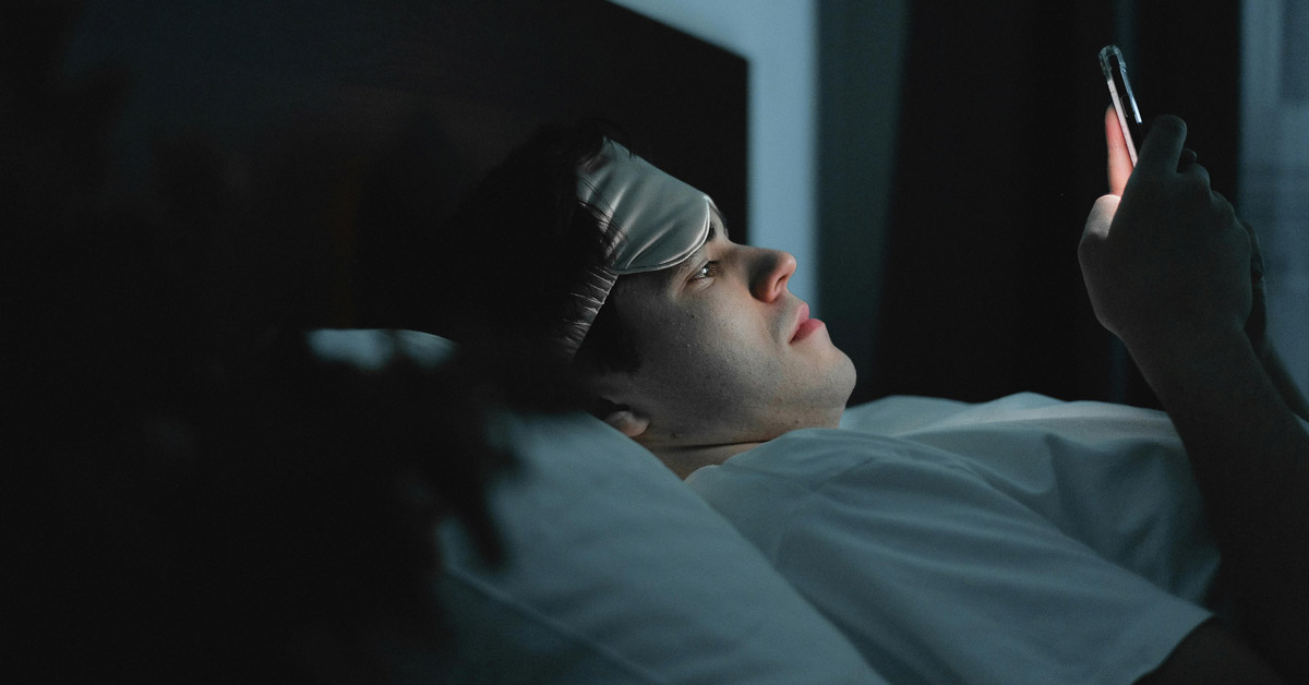 A man on his phone in bed