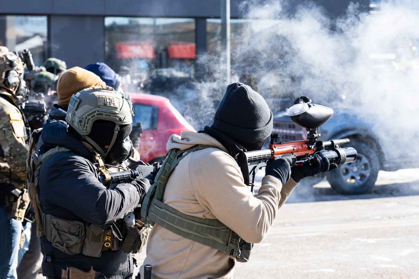 Two ICE agents shoot "less lethal" bullets and tear gas into a crowd of protesters in Minneapolis