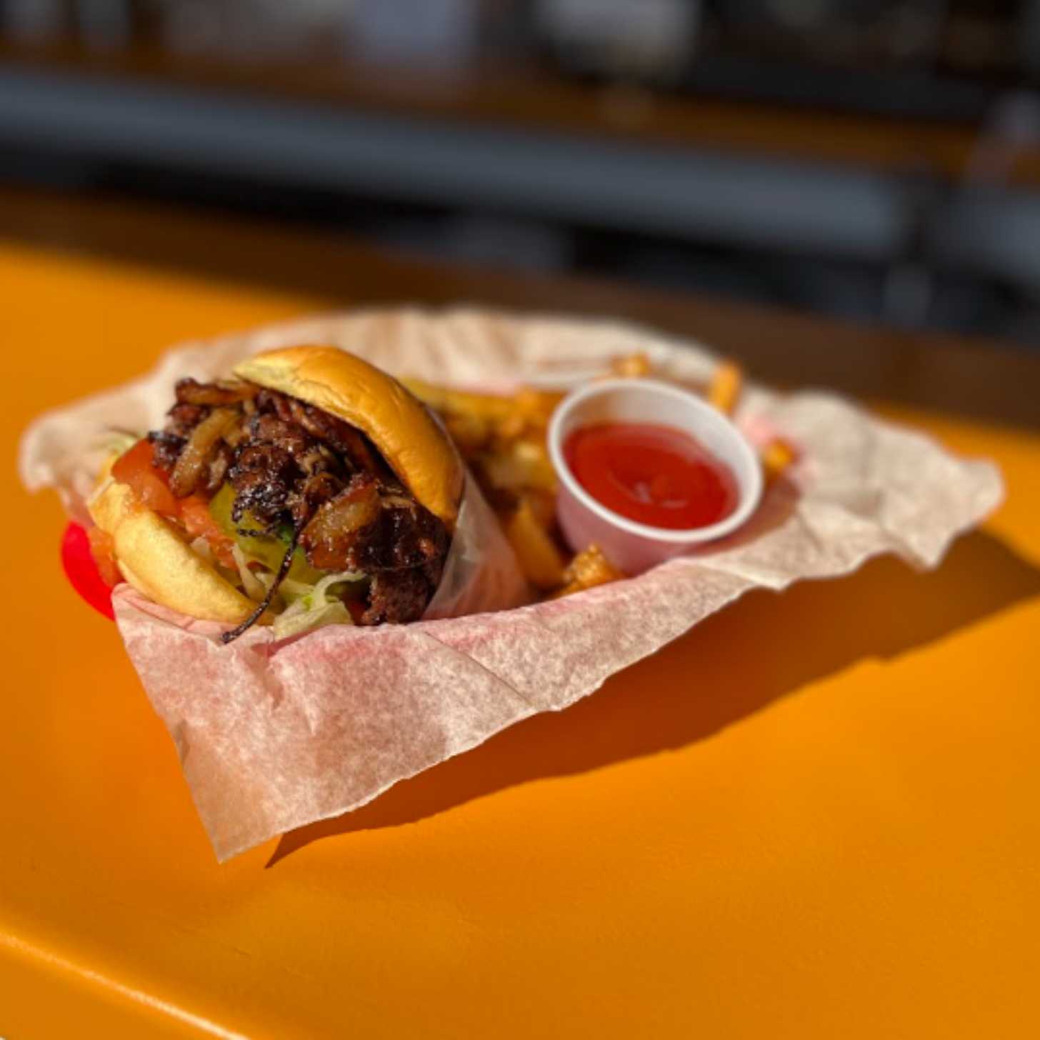 A smash burger in a diner basket on a yellow counter