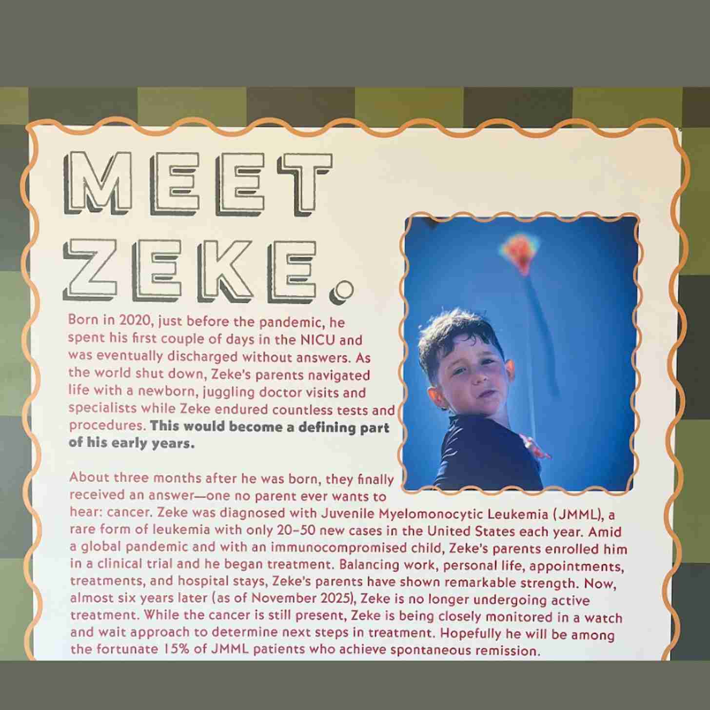 A sign says MEET ZEKE. In smaller font the story of Zeke, a boy with leukemia is detailed. A picture of him flying a kite is in the upper right hand corner.