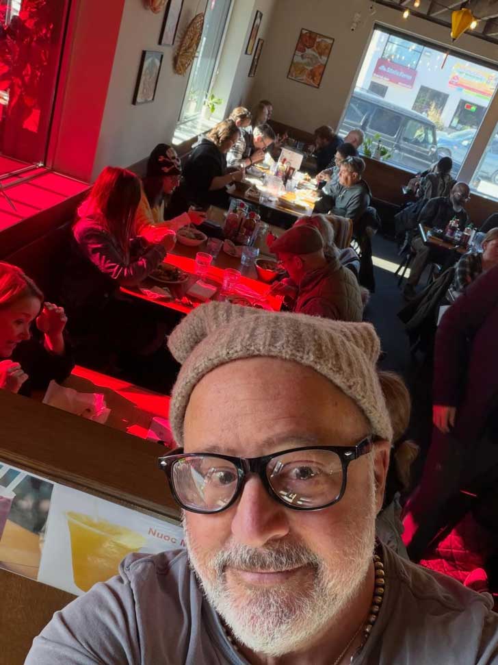 Chef Andrew Zimmern takes a selfie with a team of people inside of a Minneapolis restaurant