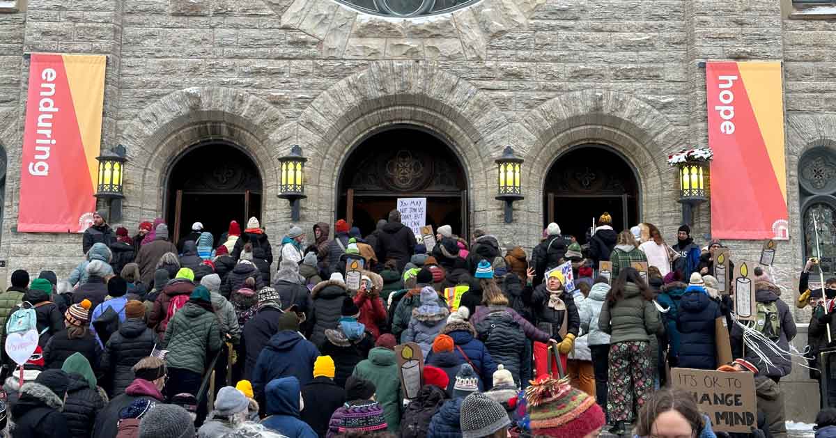 A group of protesters sing outside of a Minneapolis church