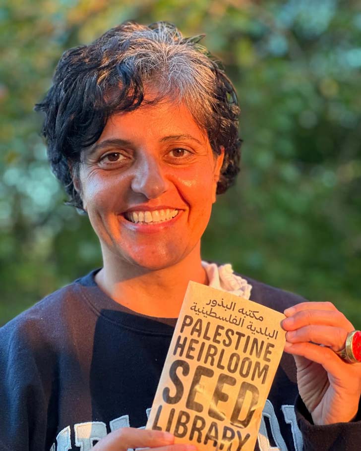 A Palestinian woman, Vivien Sansour, stands outside, holding a packet of seeds from the Palestine Heirloom Seed Library