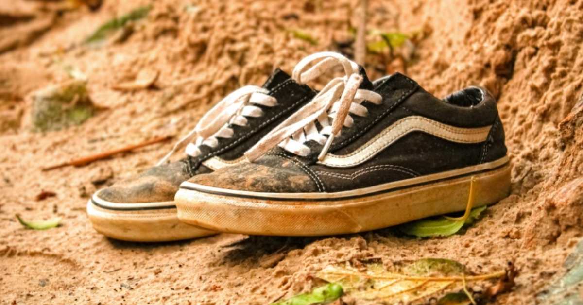 Dirty old sneakers in a mud puddle
