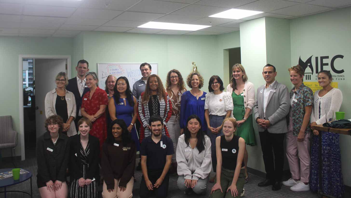A group of students, teachers, and lawmakers smile together in Illinois