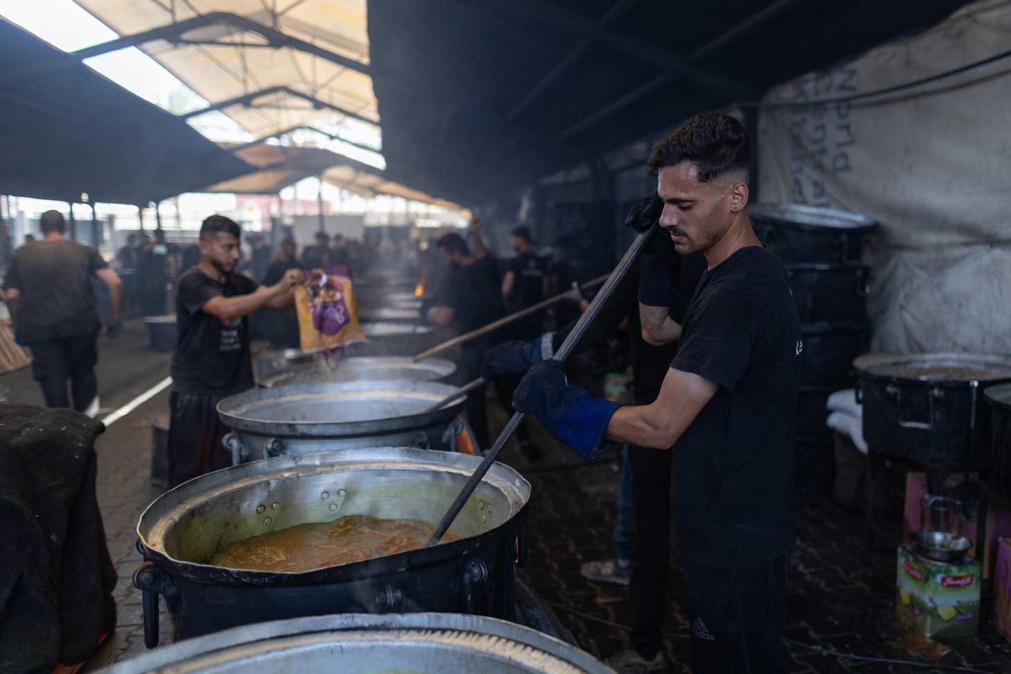 A man stirs a giant pot of soup in a World Central Kitchen location in Gaza