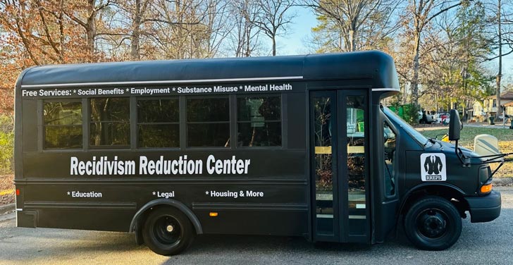 A bus painted black with white text that says "Recidivism Reduction Center" on the side
