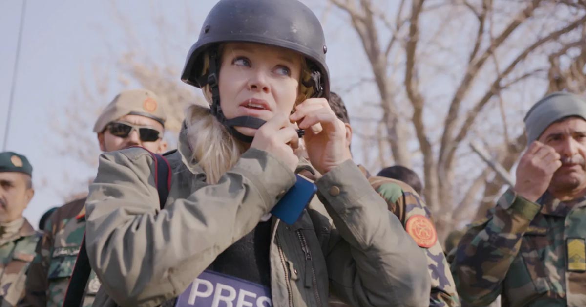 War reporter Jane Ferguson puts on a helmet over a protective "Press" vest