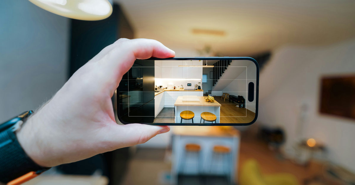 A person holds up a smartphone to take a photo of an apartment