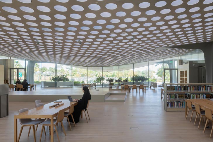A woman in a hijab studies inside of the library of the Al-Mujadilah Center and Mosque for Women
