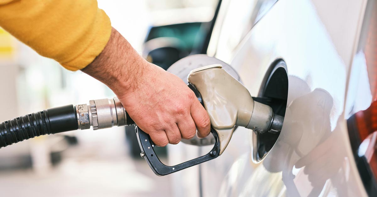 A close-up of a man's hand on a gas pump as he fills up his vehicle