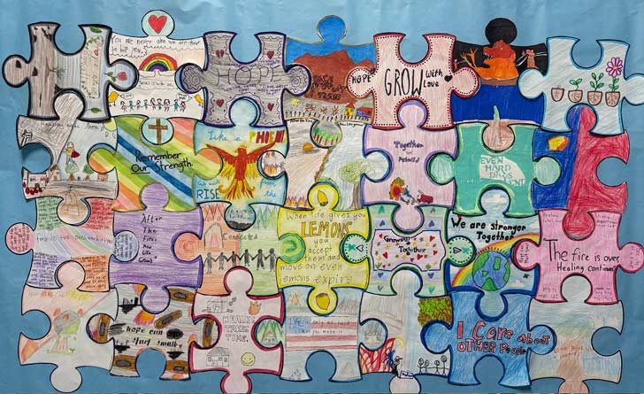 A classroom bulletin board is covered in hand-colored puzzle pieces