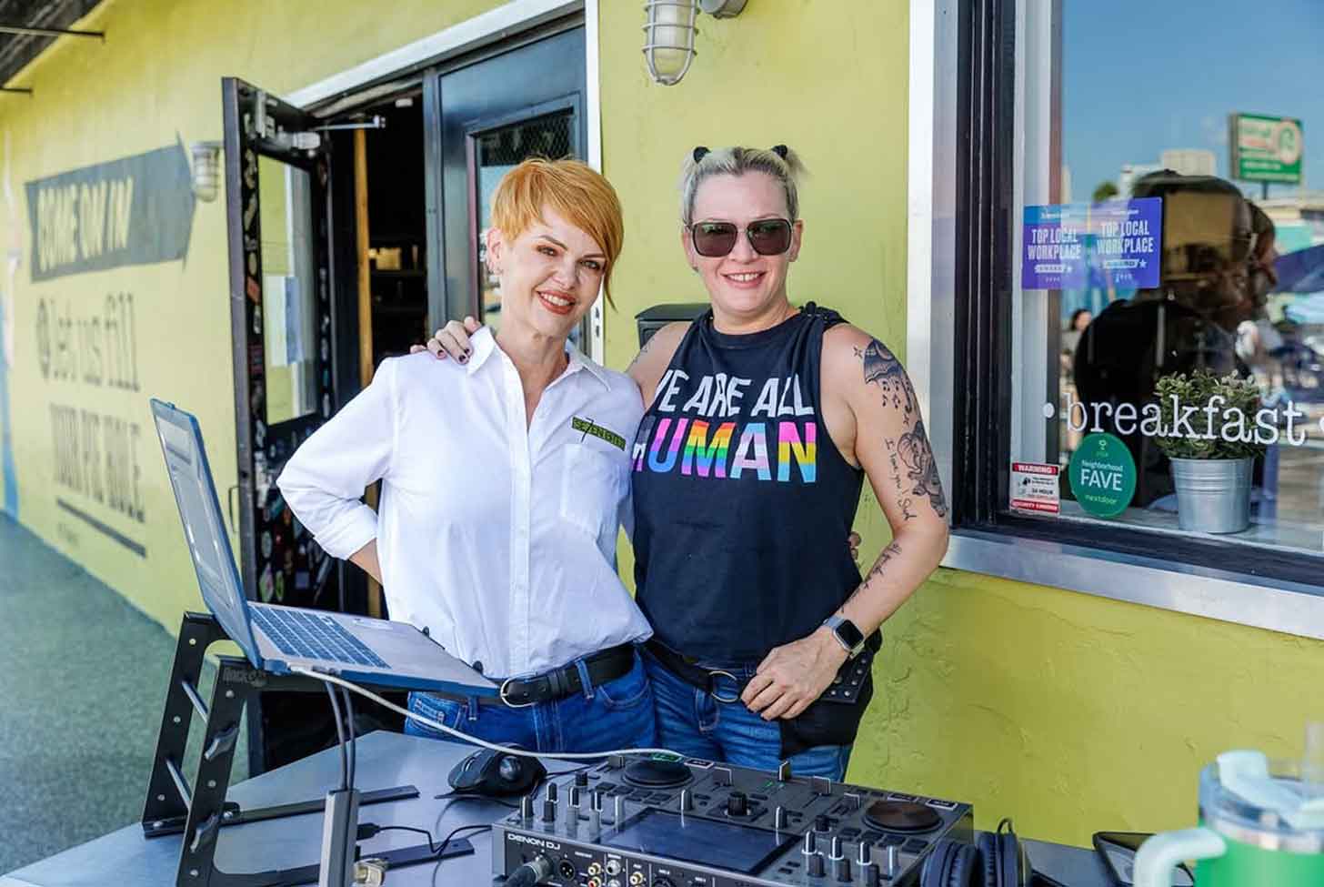 Two women stand next to each other smiling outside of Se7enbites in Orlando, Florida