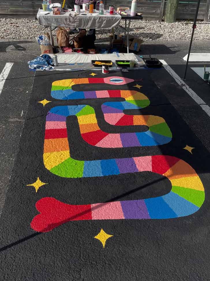 A colorful mural of a snake with rainbow stripes in a Florida parking lot