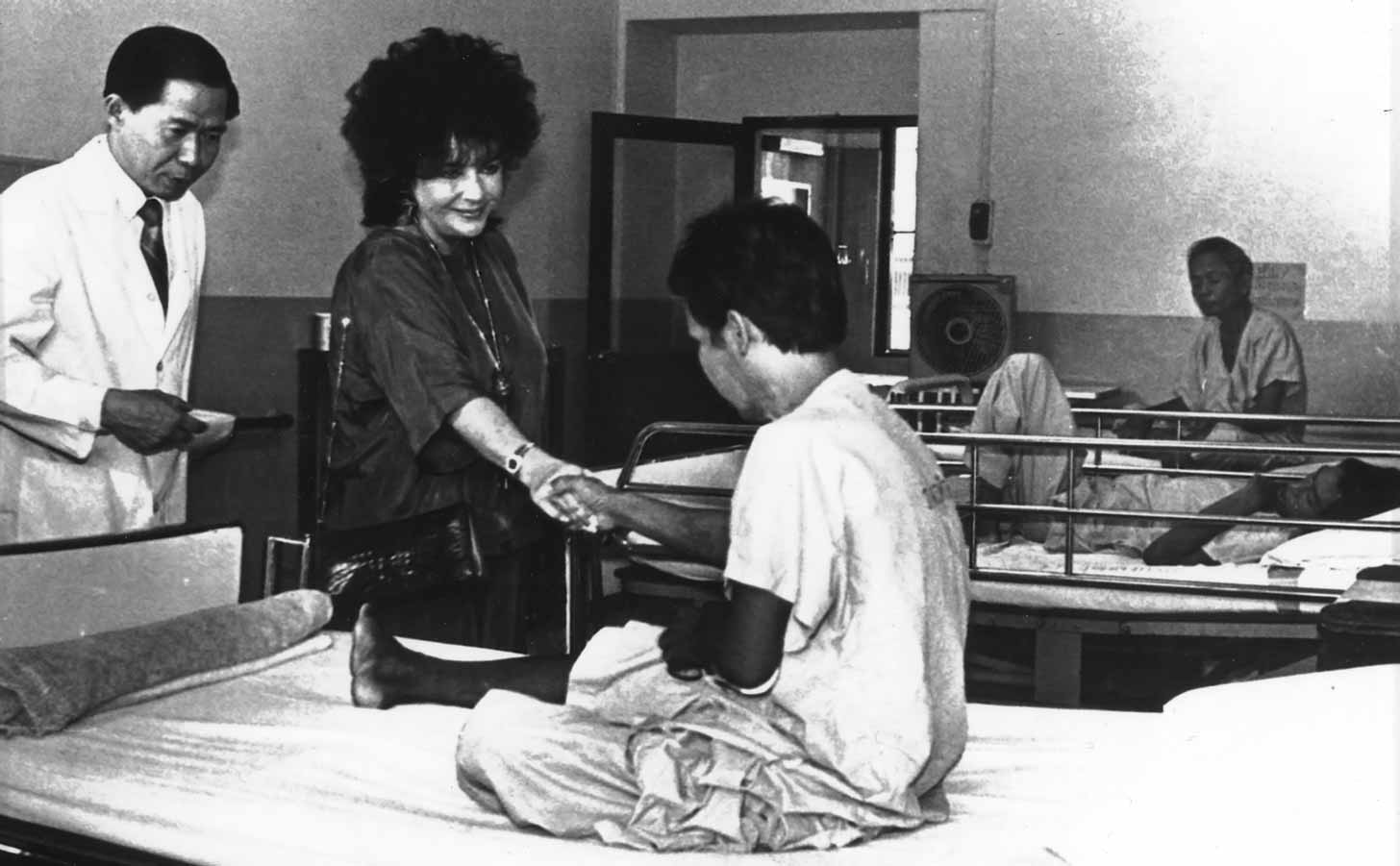 A black and white photo of Elizabeth Taylor meeting an HIV patient
