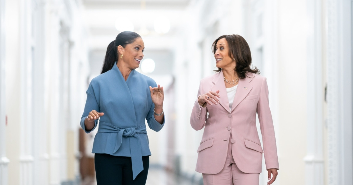 Kamala Harris in a pink suit talking with Soledad O'Brien in a blue belted blazer