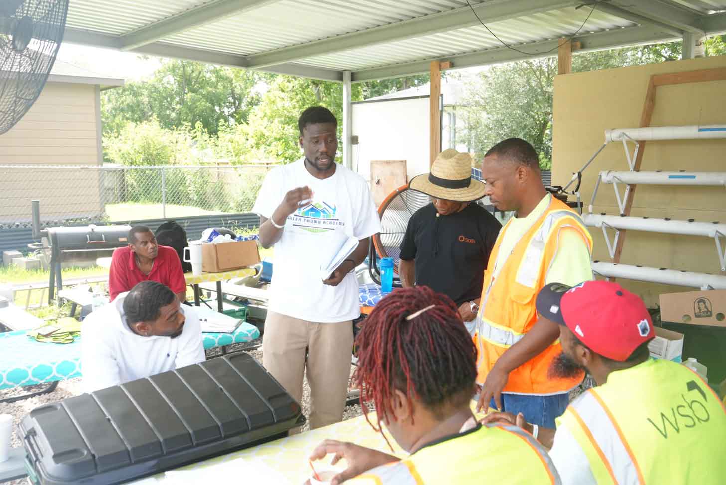 A group of students and instructors gather to learn about solar panel installation