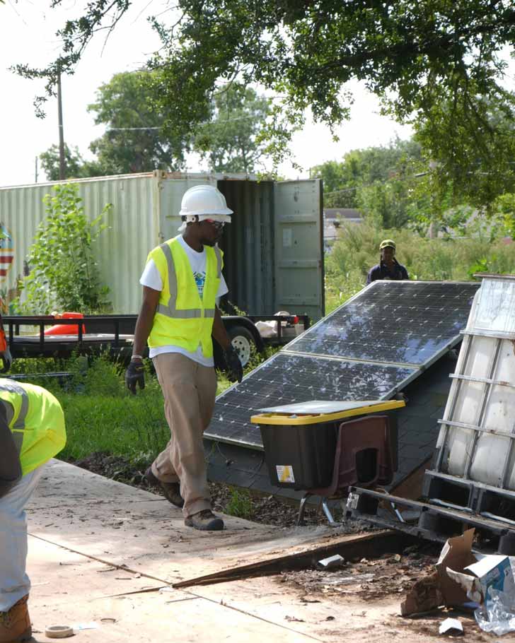 A Black solar technician walks on a job site in Texas