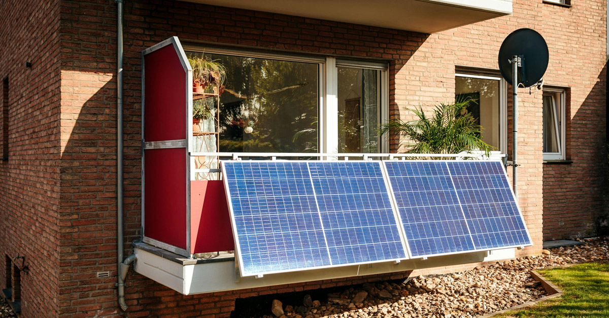 A solar panel hangs from a red balcony