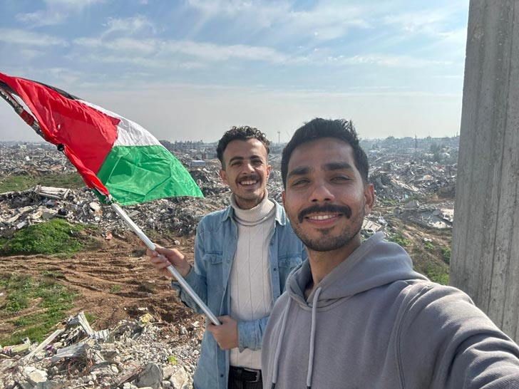 Two men take a selfie in Gaza, holding the Palestinian flag