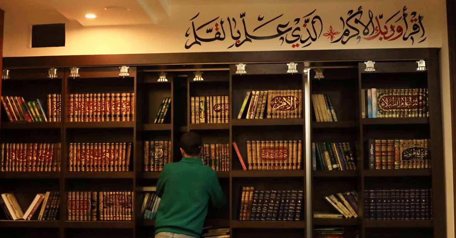 The back of a man looking at a bookshelf in the Phoenix LIbrary in Gaza