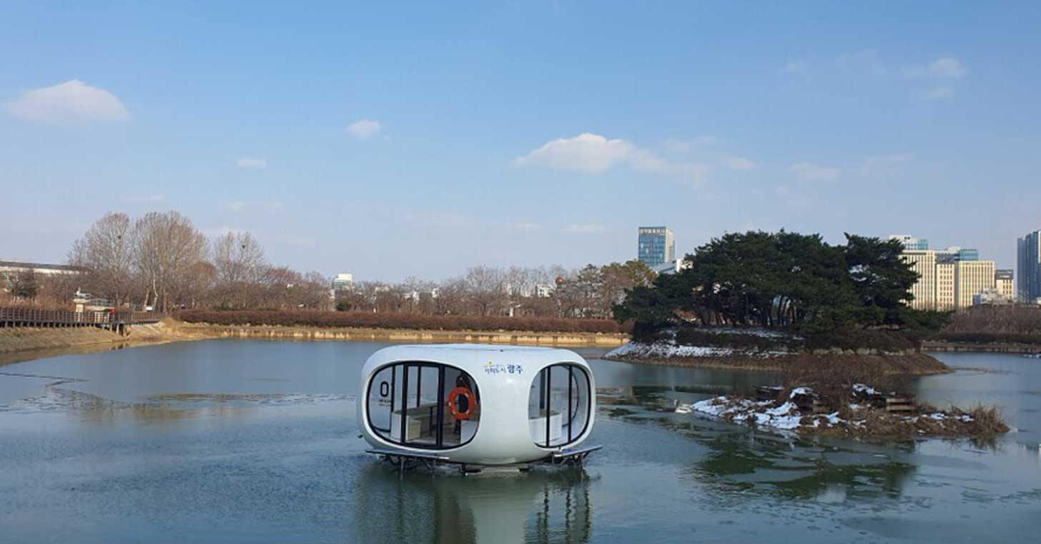 An autonomous ferry sits on water just outside of a city in Korea