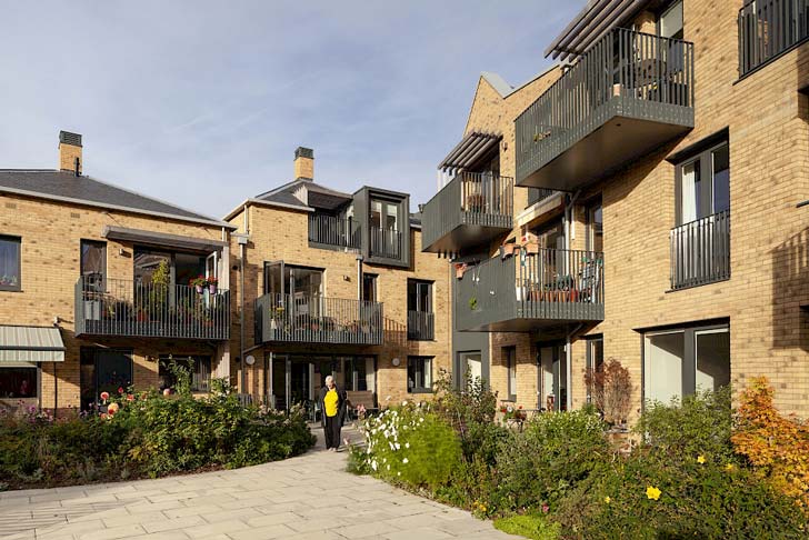 An elderly woman walks out of a brick apartment complex in North London