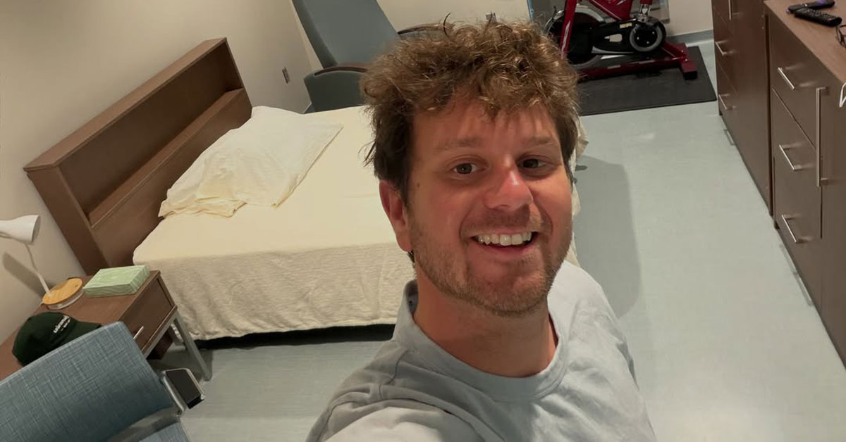 A man, Jake Rosmarin, smiles in a selfie taken in a biocontainment quarantine unit in Omaha, Nebraska