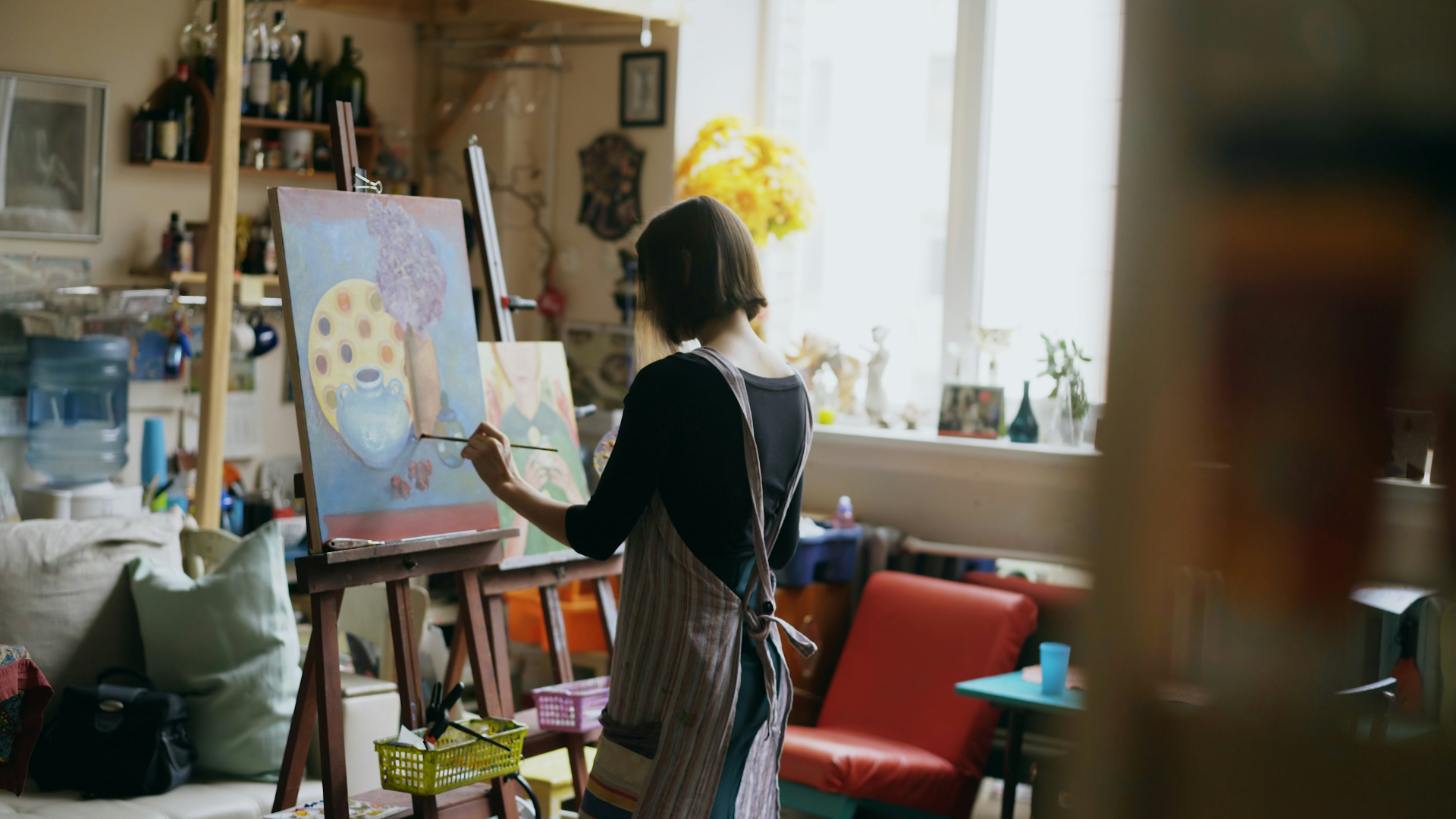 A woman paints in a cozy studio