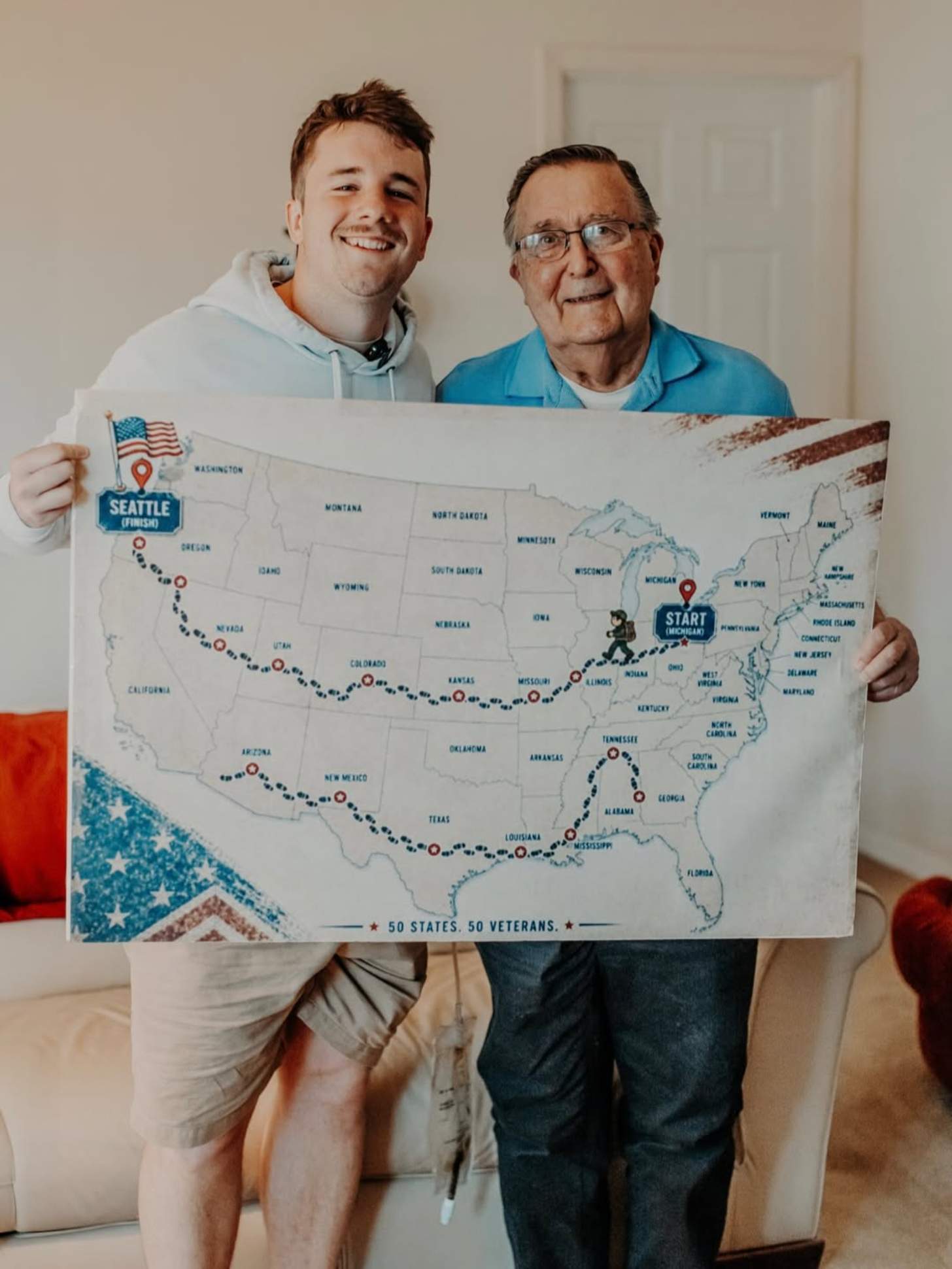 A young man, Sam Weidenhofer, and an older man, veteran Ed Bambas, smile together while holding up a map of the United States