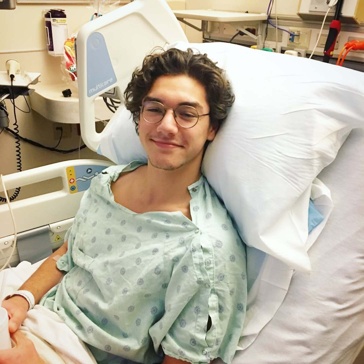Actor Belmont Cameli sits in a hospital bed