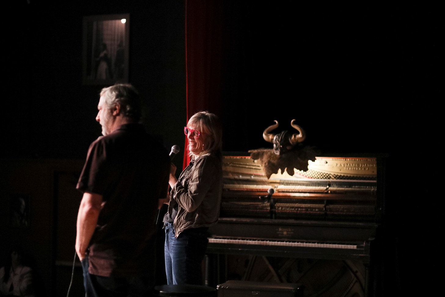 Maria Bamford and Judd Apatow stand on stage in a comedy club