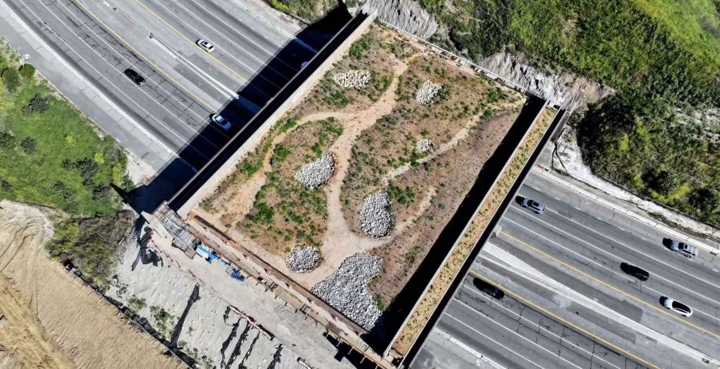 An aerial view of the Wallis Annenberg Wildlife Crossing in L.A. Route 101. It is mostly complete.