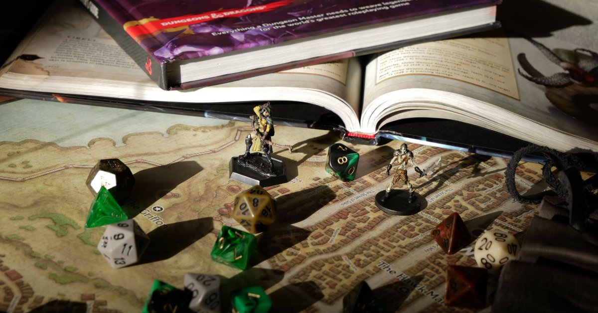 Dice and mini figurines on a table next to Dungeons & Dragons game books