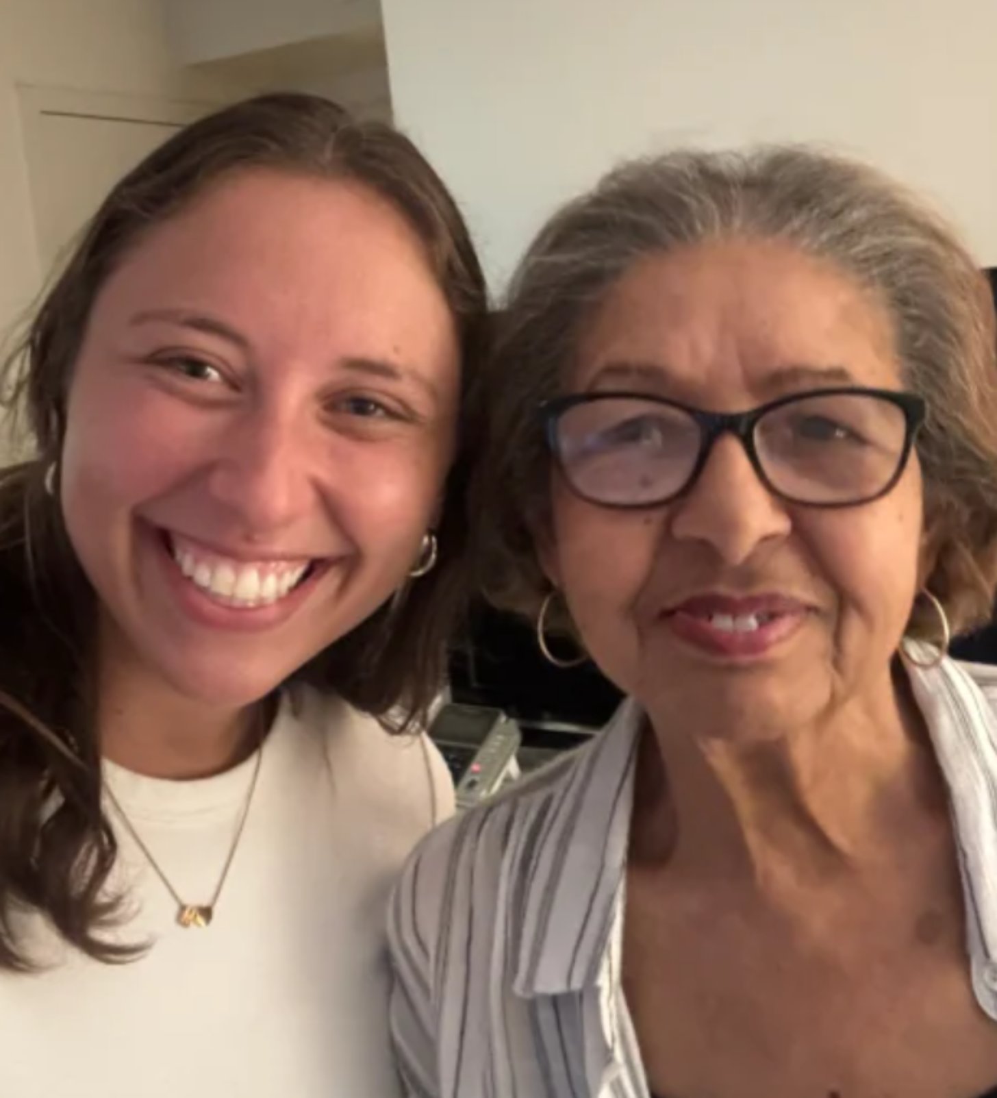 2 women, one 27, the other 81, smile as they stand close together