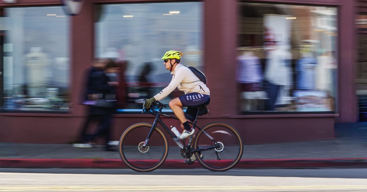 A male cyclist ride a bike down a nondescript city street