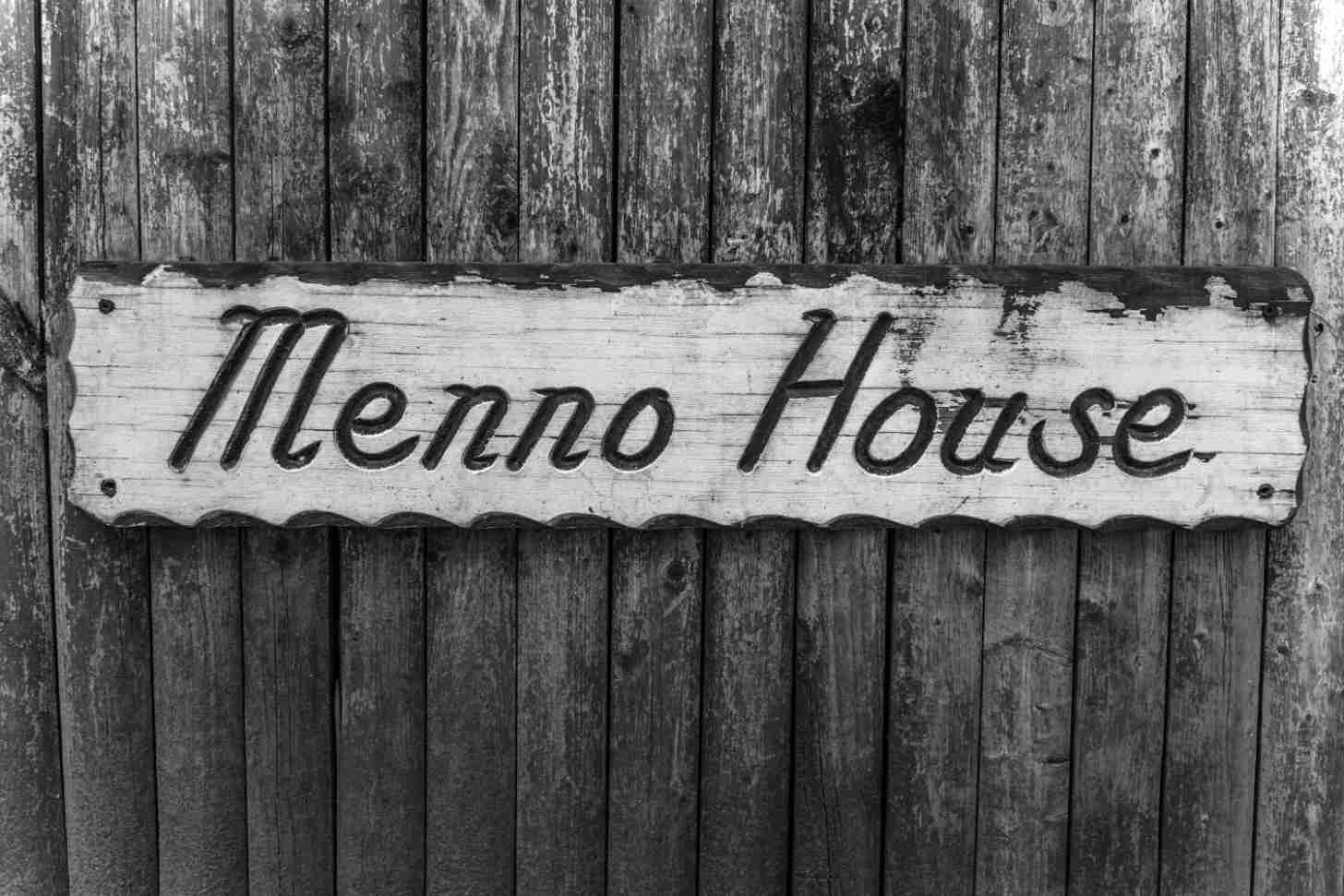 A black and white photo of a sign reading "Menno House"