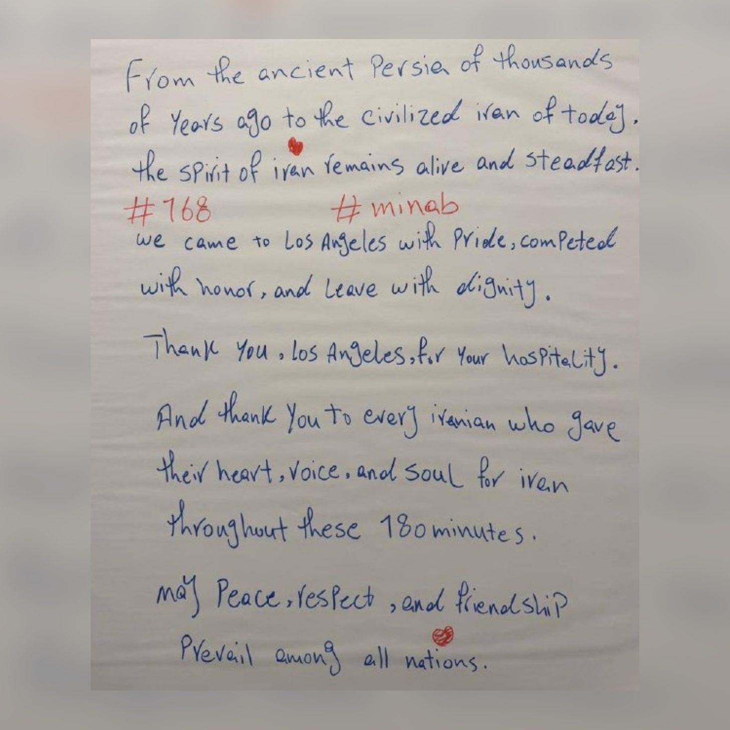 A handwritten note in blue ink that reads: "From the ancient Persia of thousands of years ago to the civilized Iran of today, the spirit of Iran remains alive and steadfast. We came to Los Angeles with pride, competed with honor, and leave with dignity. Thank you, Los Angeles, for your hospitality. And thank you to every Iranian who gave their heart, voice, and soul for Iran throughout these 180 minutes. May peace, respect, and friendship prevail among all nations." It is marked "#168" and "#minab" with small red hearts.