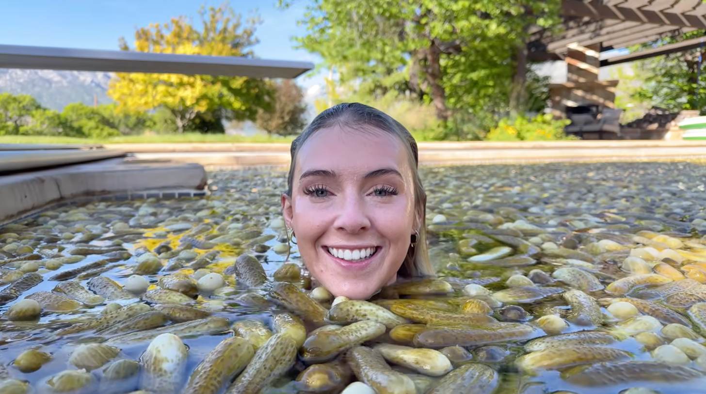 A woman, Serena Neel, swims in a swimming pool full of pickles