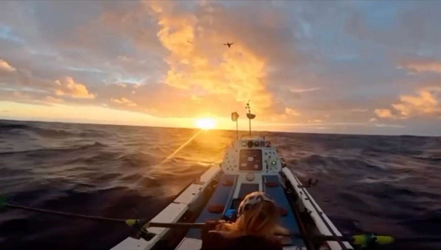 A fishing vessel sails toward a golden sunset over calm ocean waters, symbolizing hope and forward progress on the open sea.