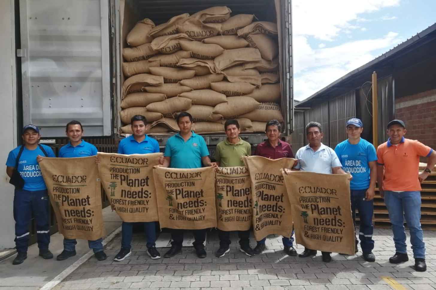 Men hold up cloth signages saying 'Ecuador. Production the Planet Needs: Forest Friendly & High Quality'
